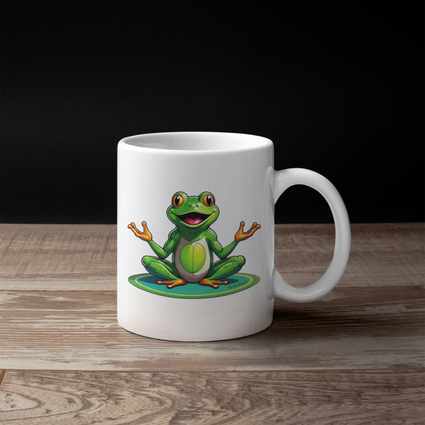 Eine Kaffeetasse mit einem Frosch im Comic-Stil, der Yoga macht, steht auf einem Holztisch