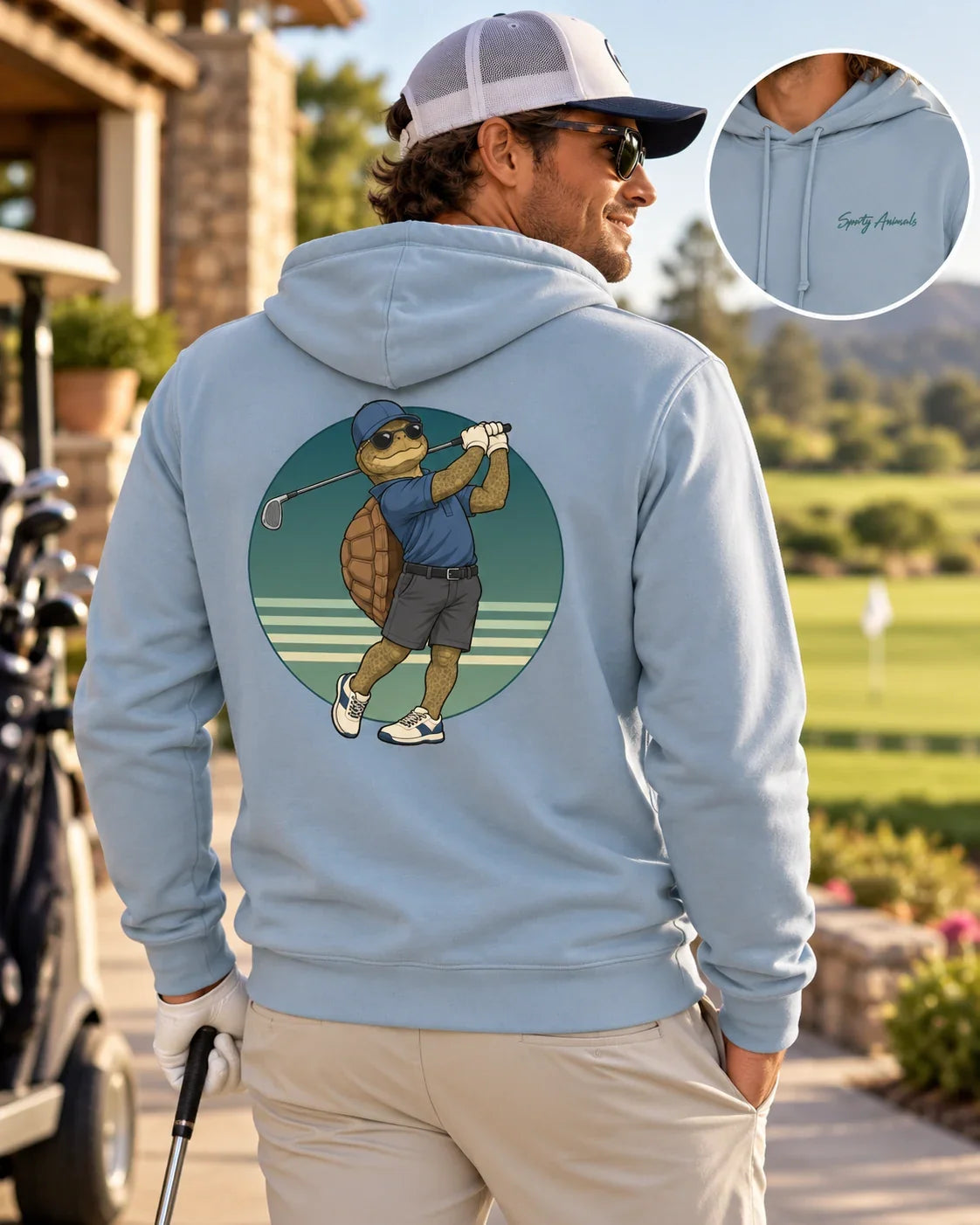 Mann trägt Golfing Turtle Herren-Hoodie in Blue Fog auf dem Golfplatz – großes Golf-Schildkrötenmotiv auf dem Rücken